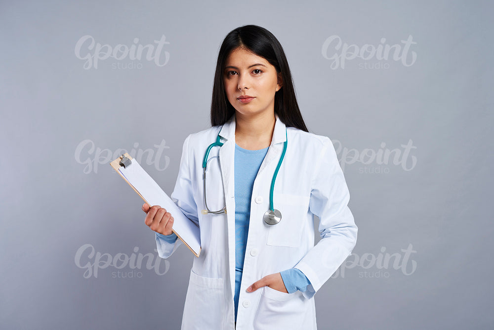 Female Asian doctor holding a clipboard with a document