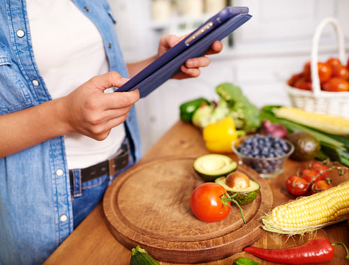 Close up of woman with digital tablet in the kitchen