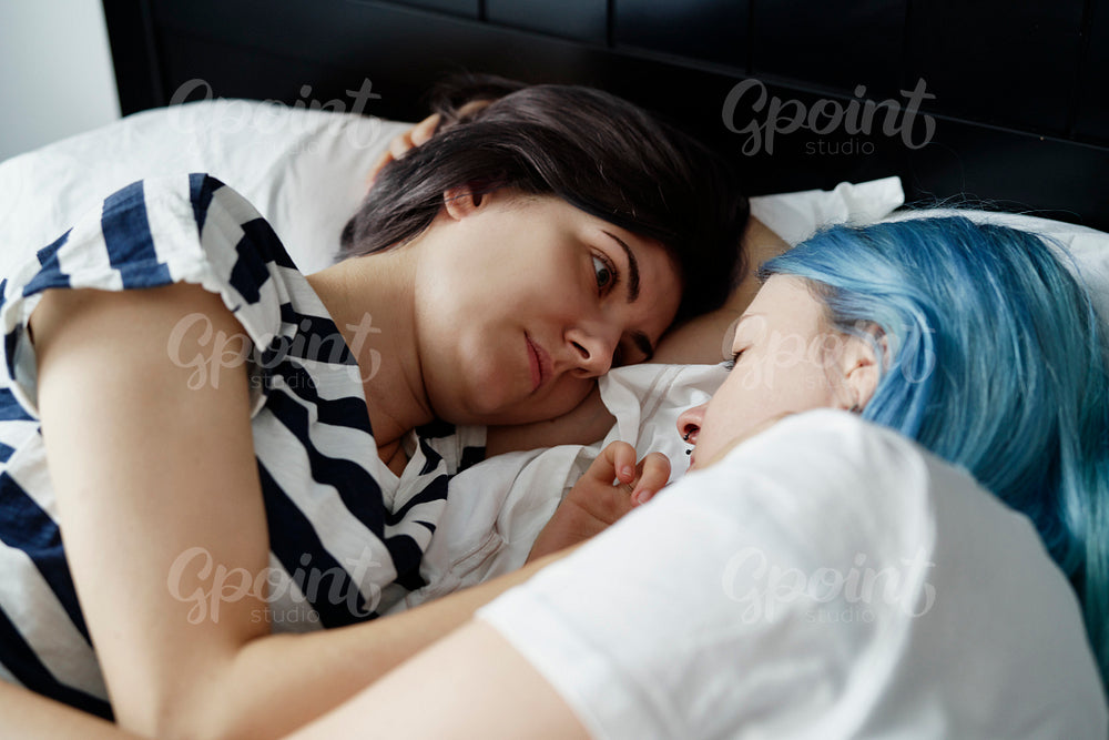 Lesbian couple lying and looking deep in the eyes