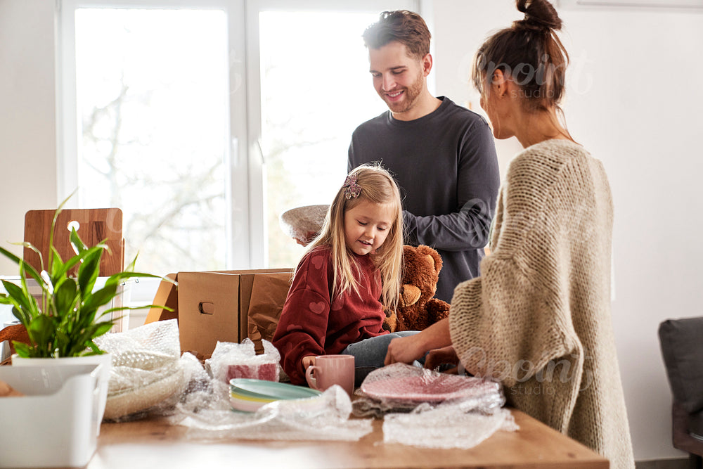 Caucasian family packing kitchen stuff in new house 