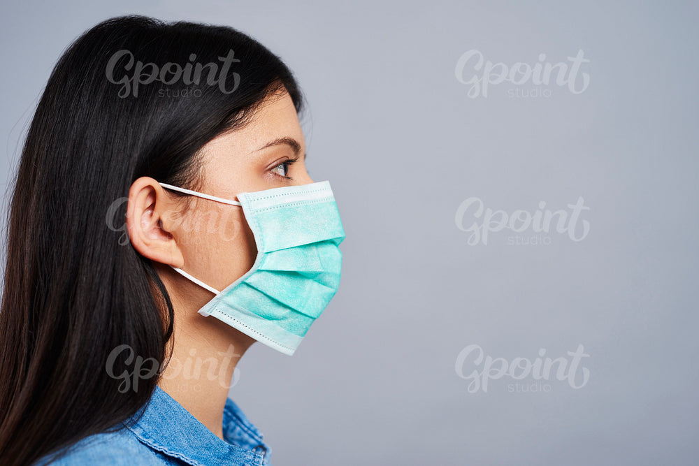 Profile view of Asian woman in protective mask