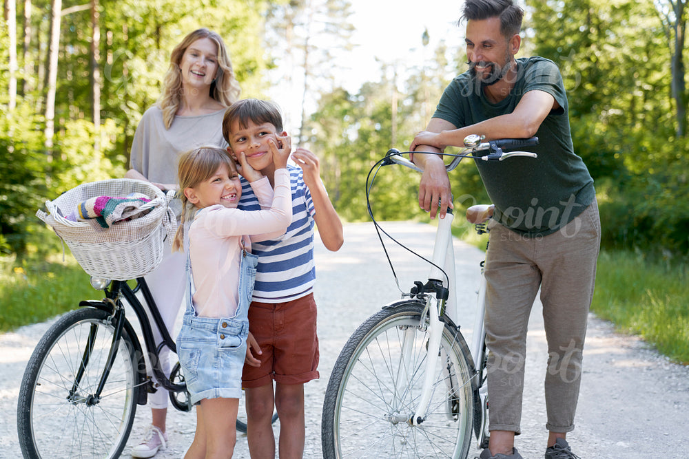 Family with playful children while bike ride in the woods