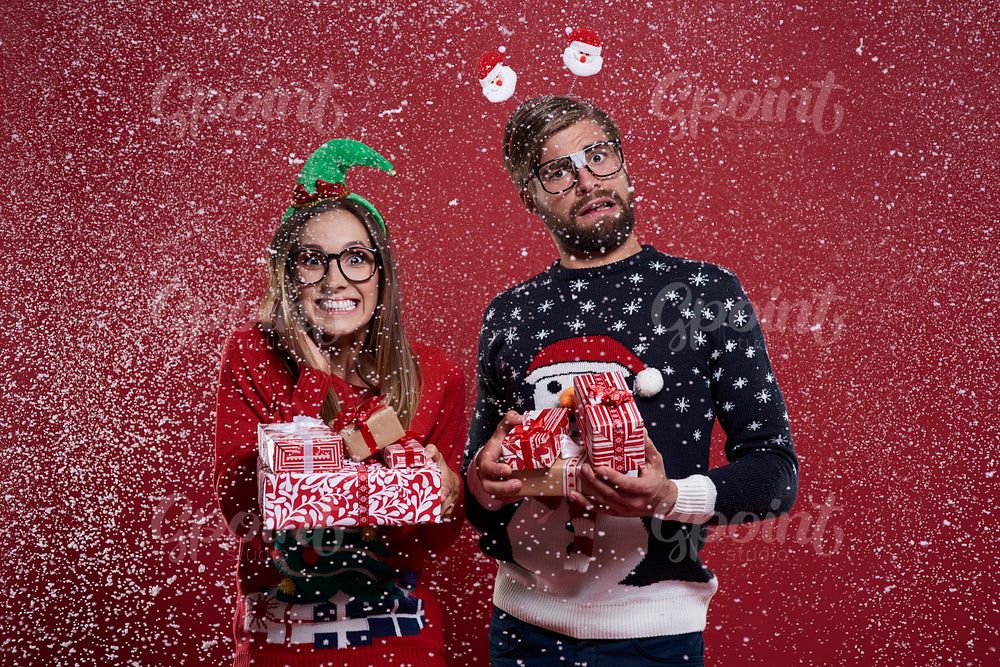 Couple carrying a pile of christmas gifts