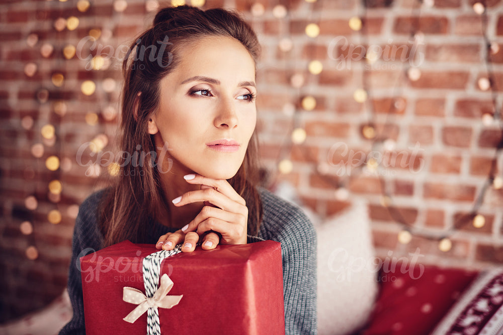 Woman with christmas present dreaming