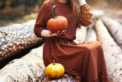 Close up of woman with pumpkin in autumn forest