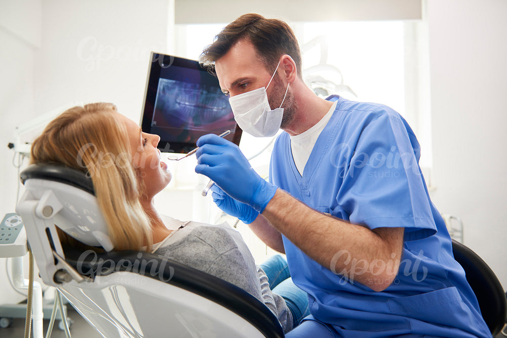 Side view of stomatologist doing his work in dentist's clinic