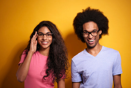 Afroamerican couple in glasses on yellow background