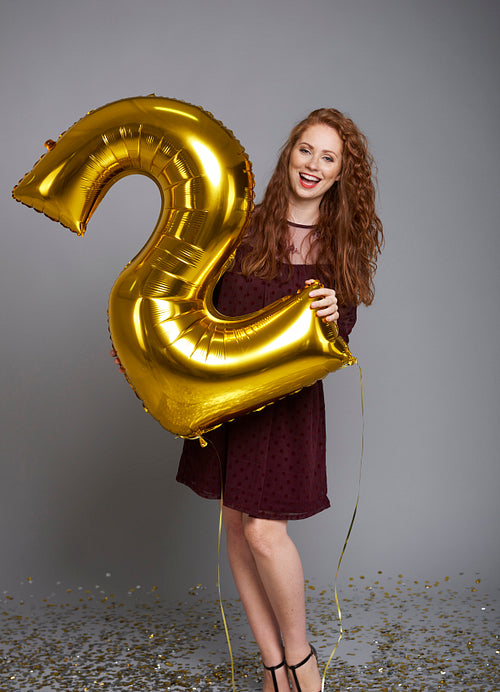 Screaming woman with balloon celebrating second birthday her company