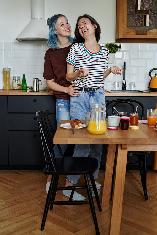 Laughing lesbian couple during breakfast