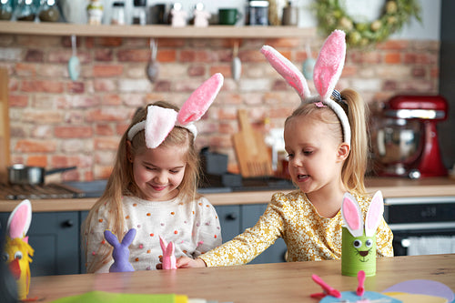 Happy two little girls have fun with Easter puppets