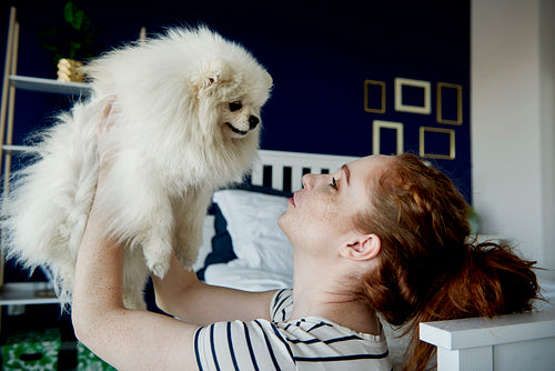 Woman giving kisses to her fluffy pet dog