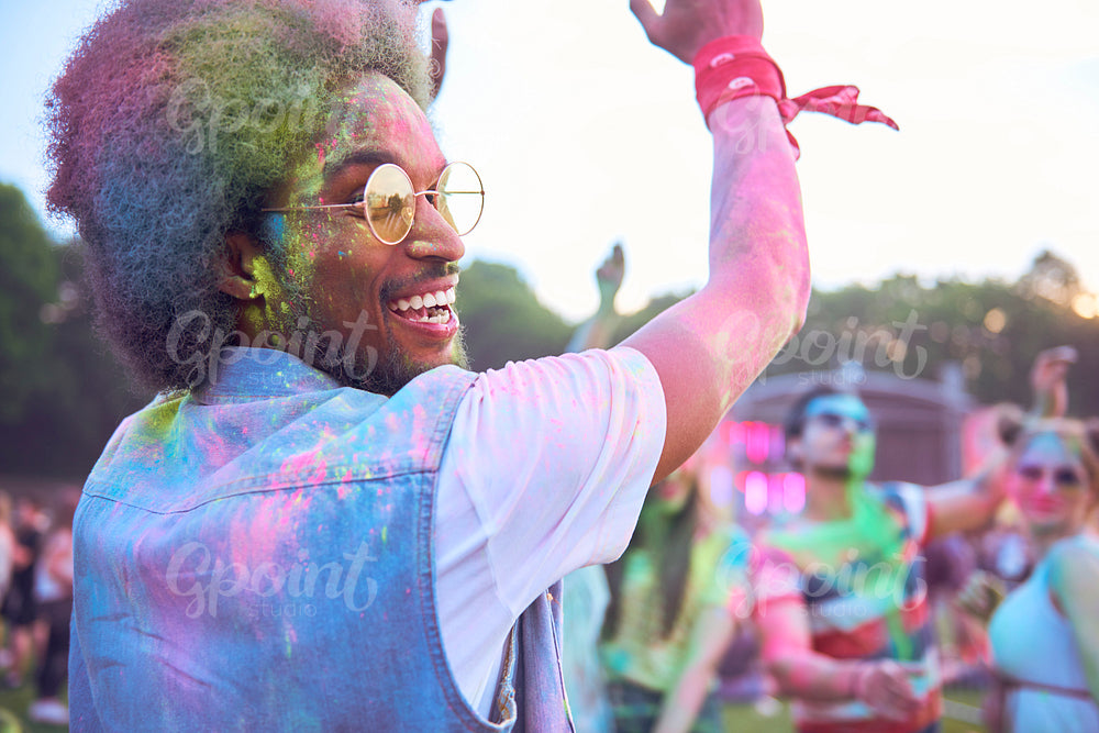 African man in holi colors dancing during music festival