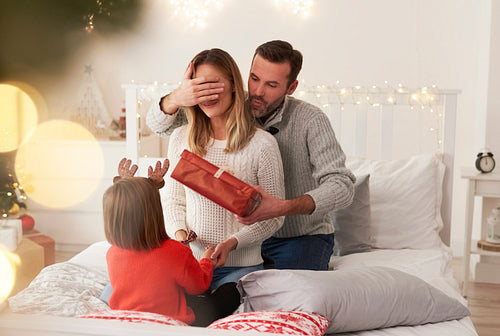 Family starting Christmas from opening presents in bed