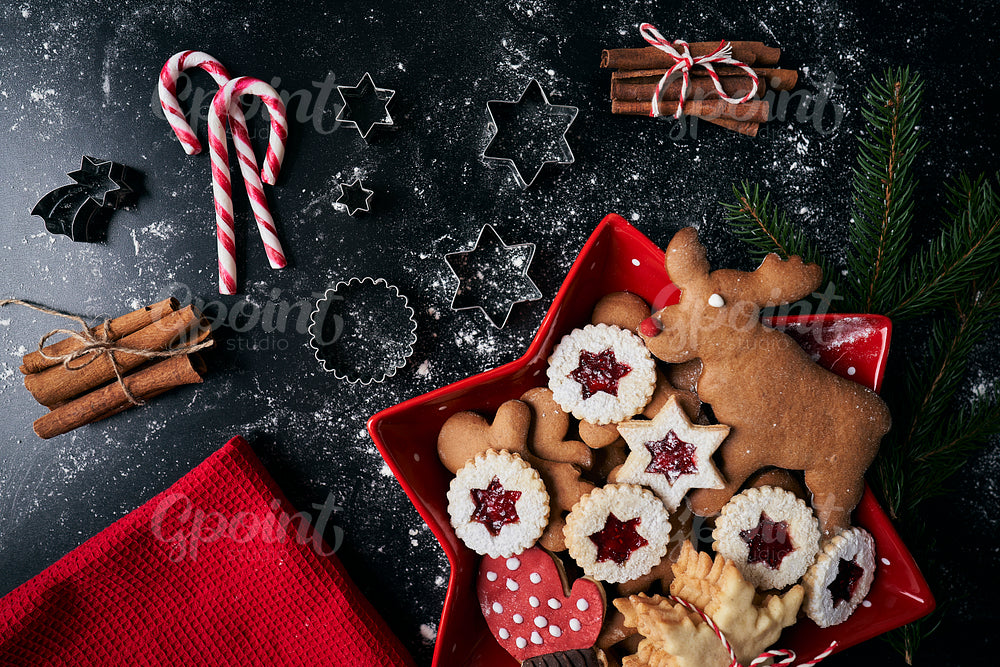 Christmas cookies in red bowl on black background