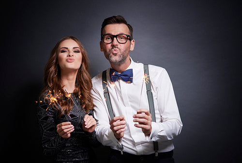 Couple with sparkler making duck face