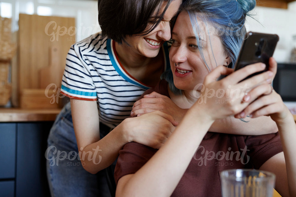 Happy lesbian couple hugging in the kitchen