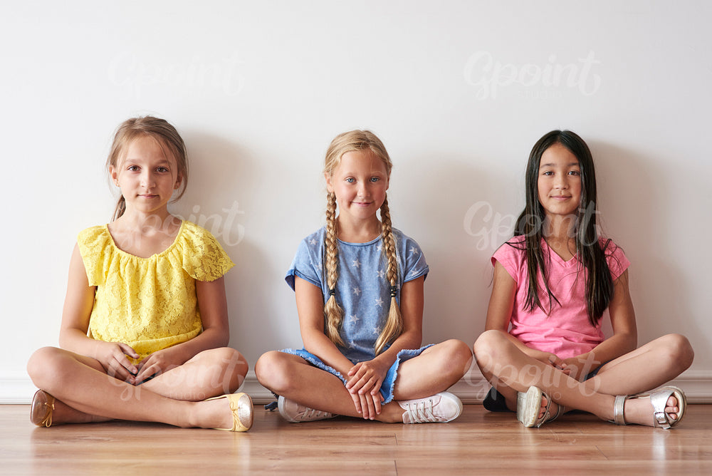 Three girls sitting with crossed legs