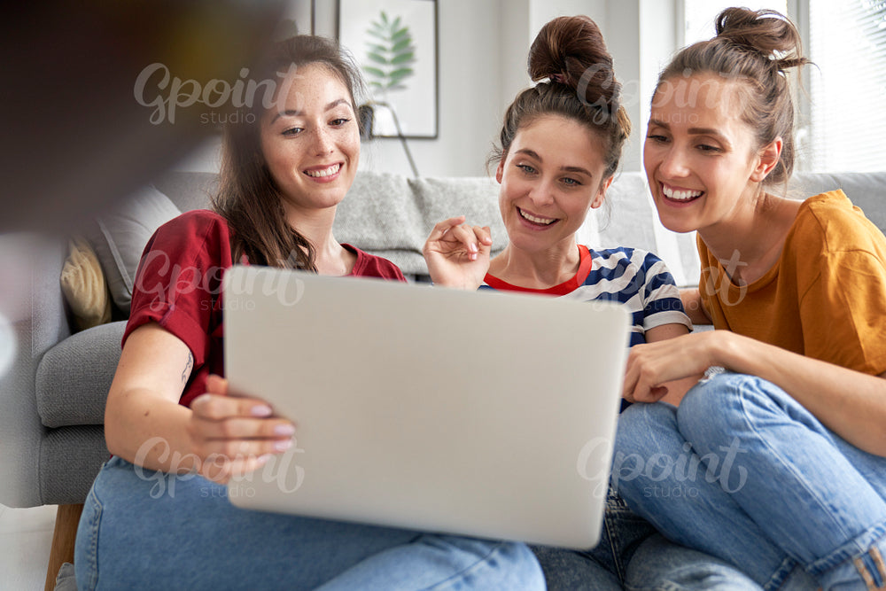 Three women browsing something on laptop