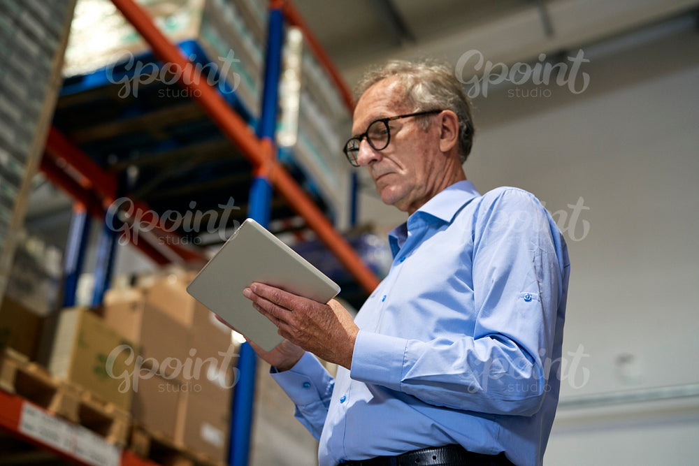 Caucasian leader in mature age analyzing document in digital tablet  