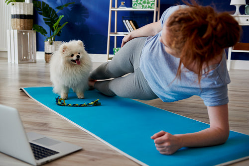 Woman doing some yoga exercises with her dog