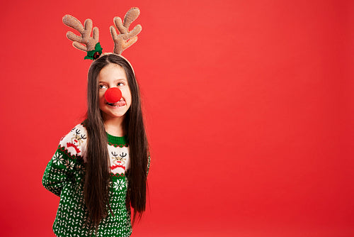 Funny girl in Christmas costume on red background