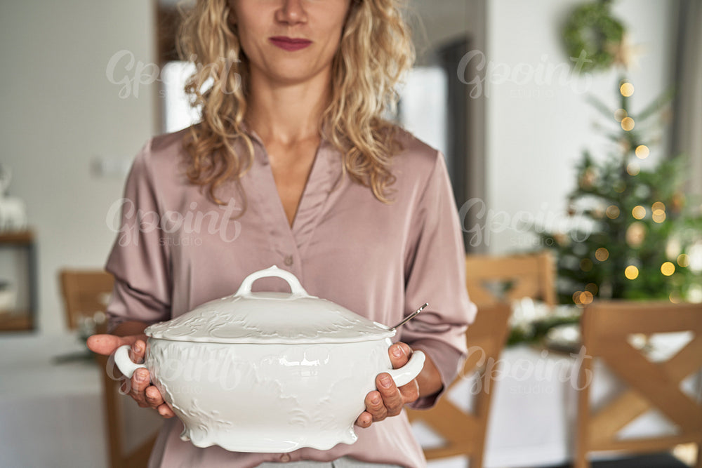 Unrecognizable caucasian woman holding the soup vase 