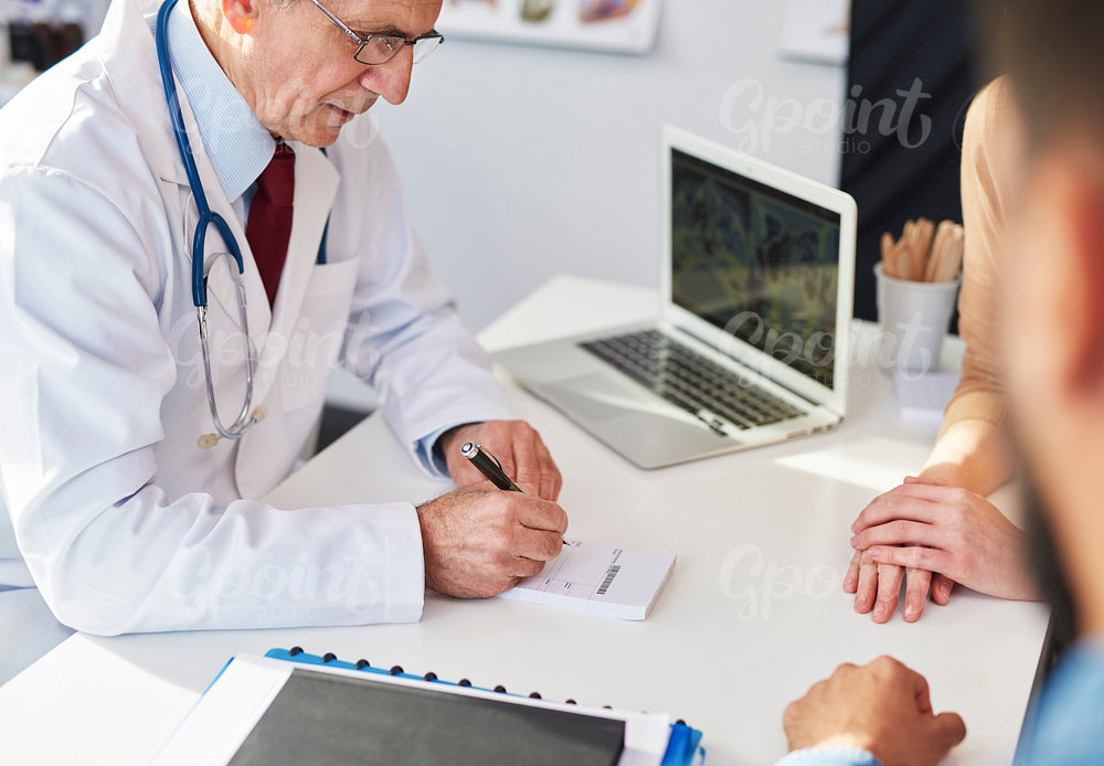 Doctor writing a prescription for his patients