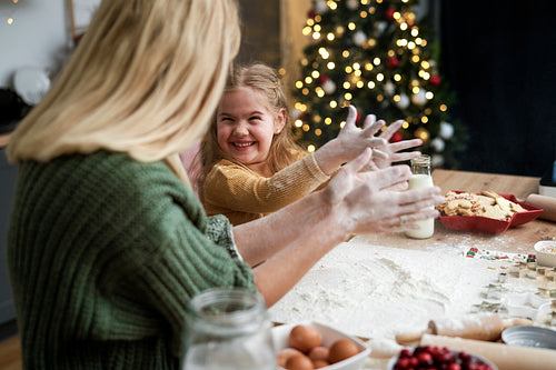 Mother and daughter have fun with flour during Christmas baking