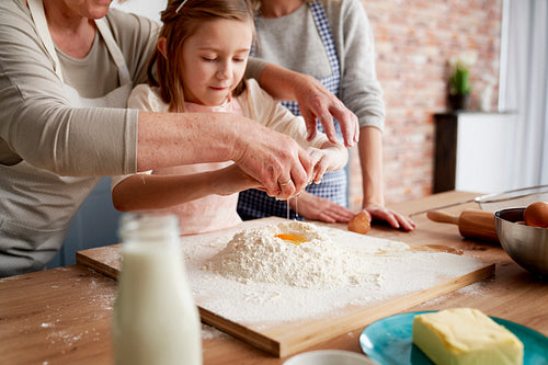 Grandmother helping girl to Easter bake