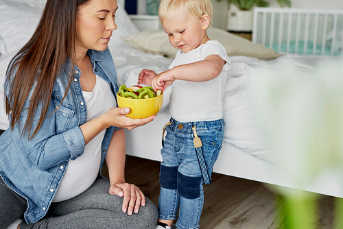 Toddler picking up fruit from the bowl