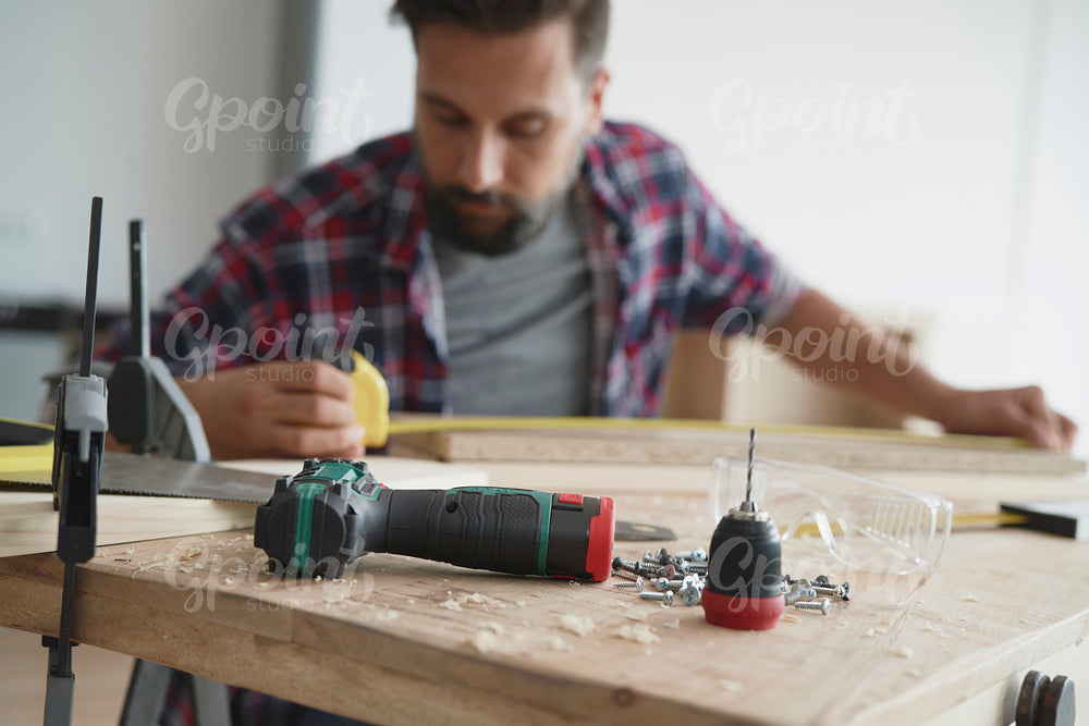 Drill lying on the table and man in the background
