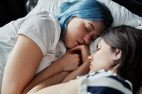 Close up of lesbian couple sleeping together in bed