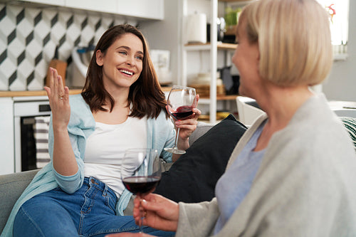 Two generation women spending time drinking wine at home