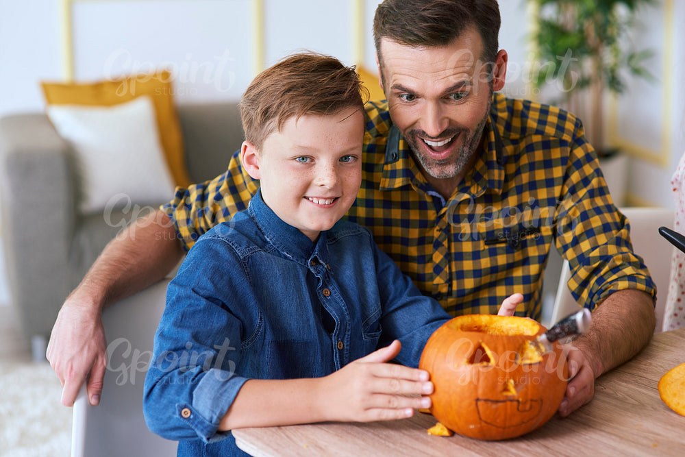 Boy and father carving pumpkin