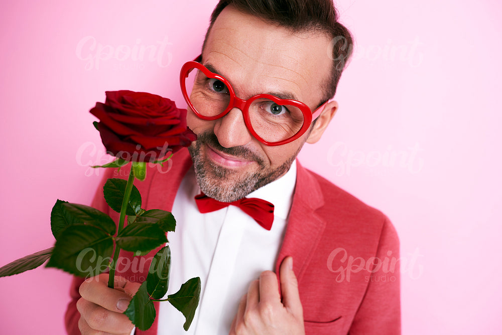 Man in red suit holding a rose