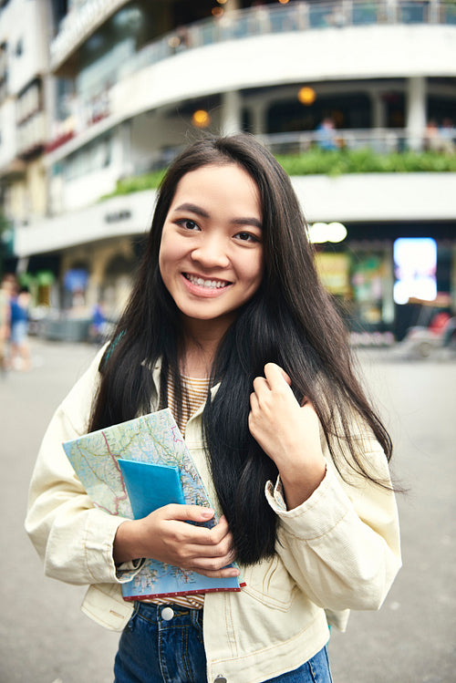 Portrait of Asian woman with passport and paper map