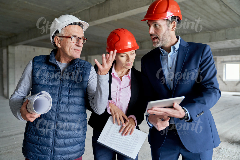 Medium shot of group of  caucasian engineers and investors discussing on construction site