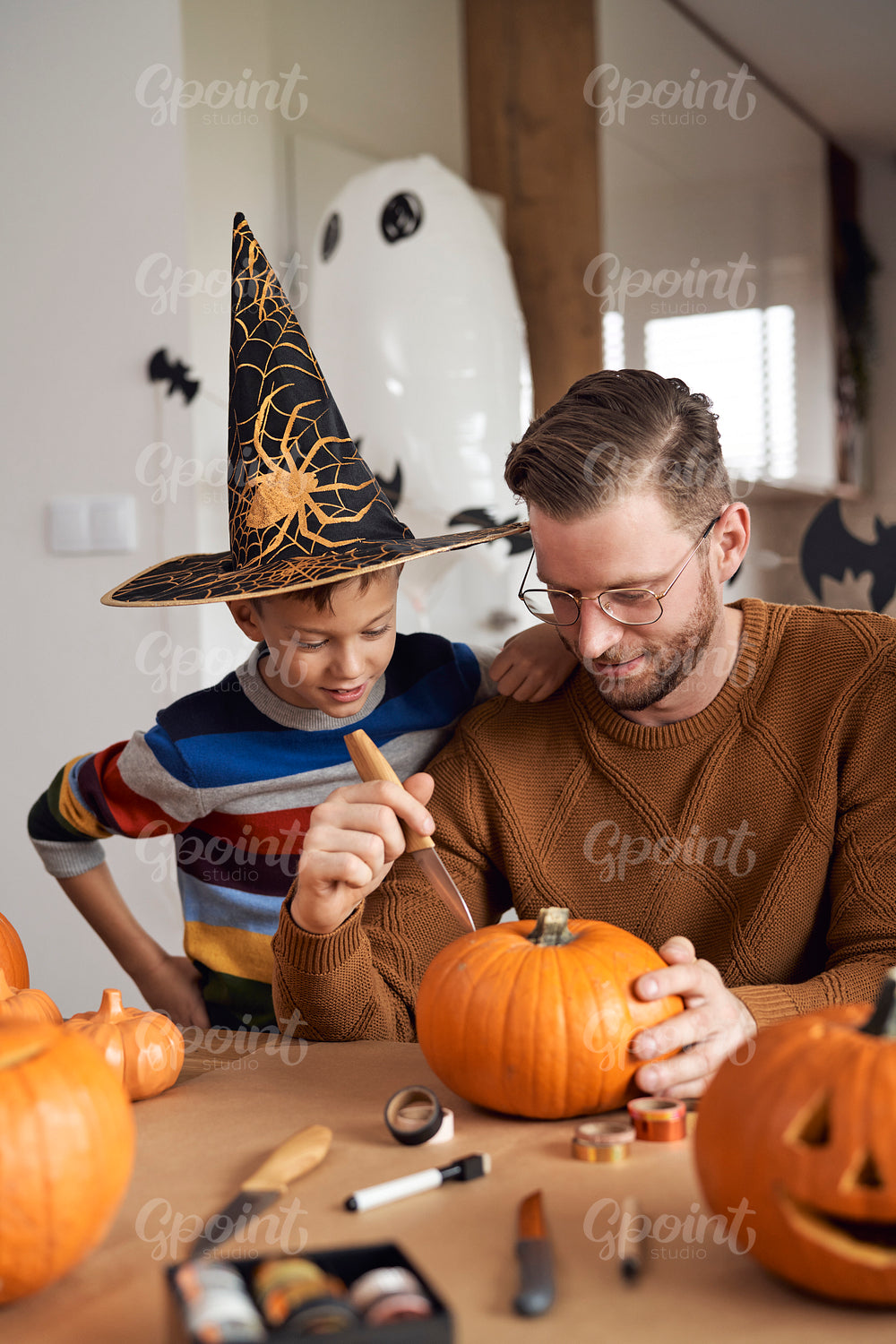 Father with son carving a pumpkin 