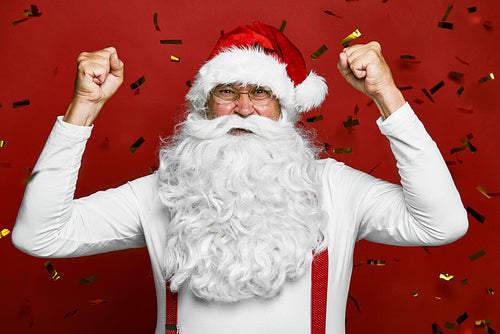 Caucasian Santa Claus cheering with confetti