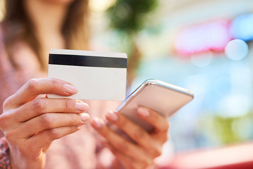 Woman using mobile phone and credit card during online shopping