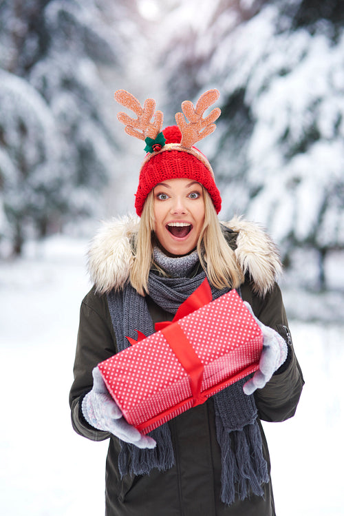 Surprised woman holding Christmas gift