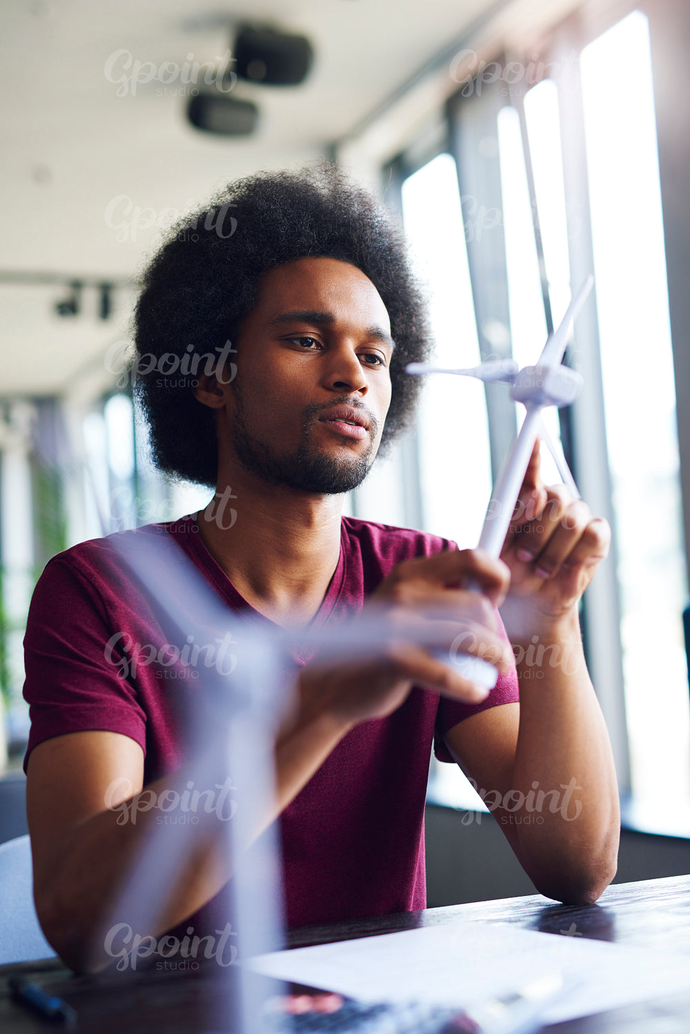 African man holding a model of wind turbine