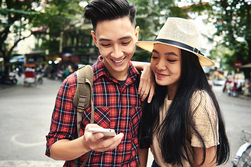 Young couple using mobile phone while traveling