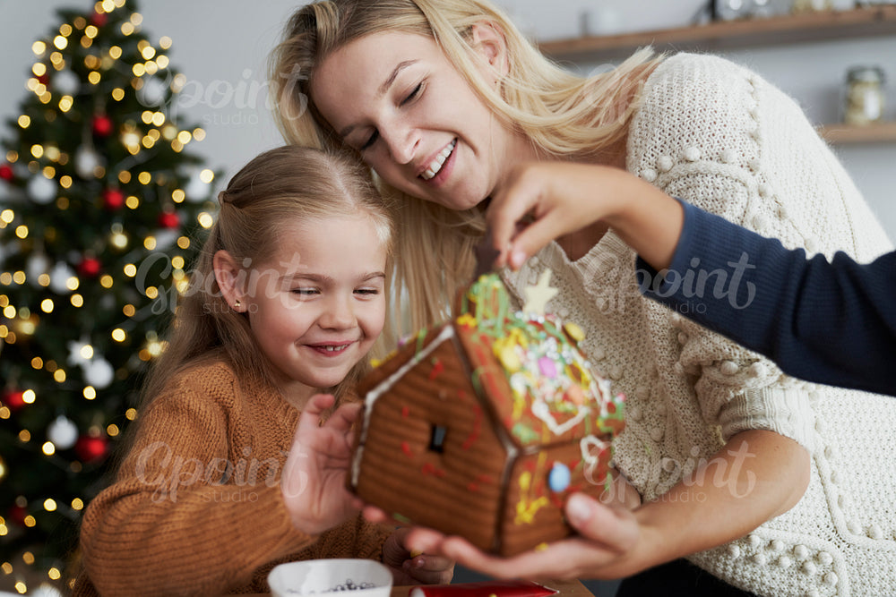 Happy  family looking at decorated gingerbread house
