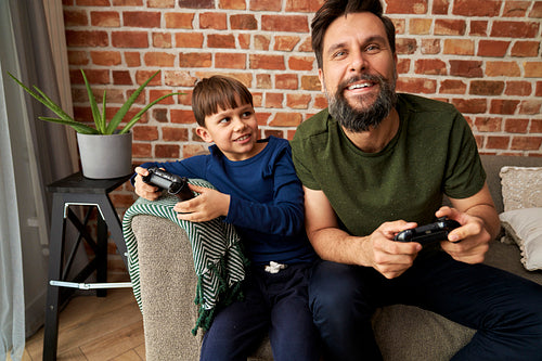 Father having fun playing video games with his son