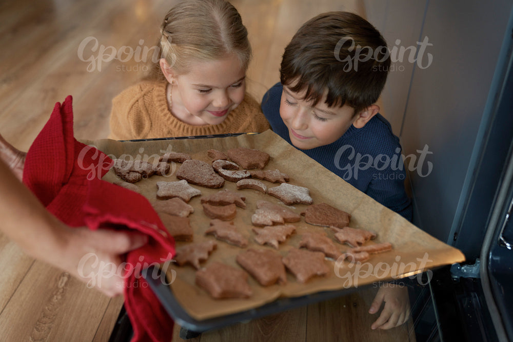 Children smelling freshly baked gingerbread cookies
