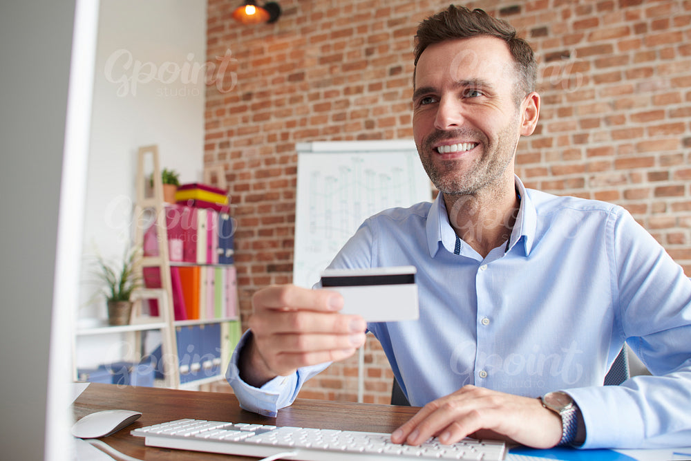 Happy man paying with credit card