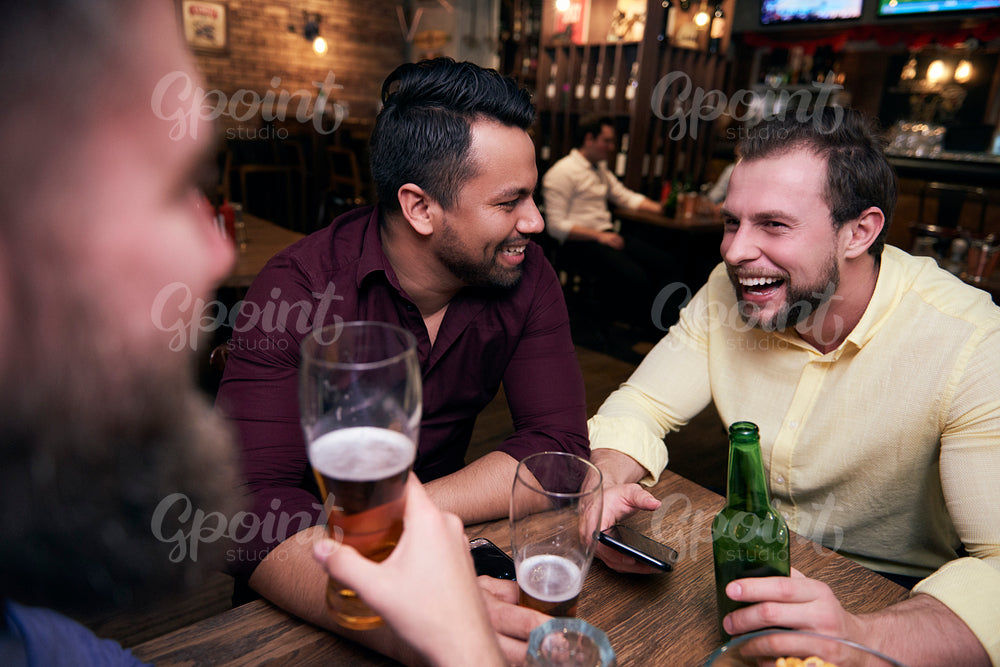 Male friends chilling with drinks at the bar