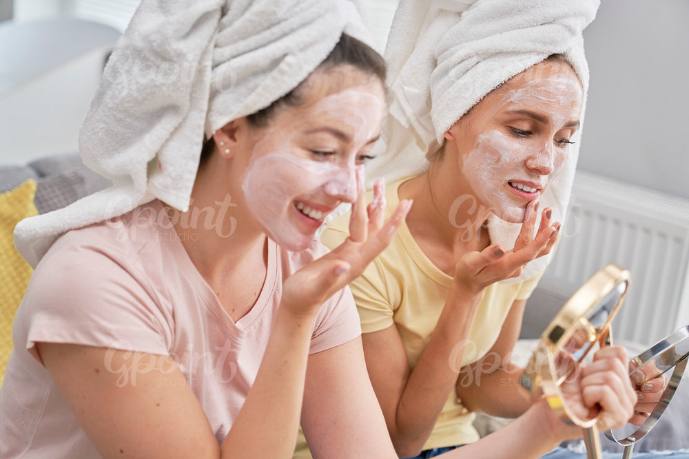 Two girls applying facial mask