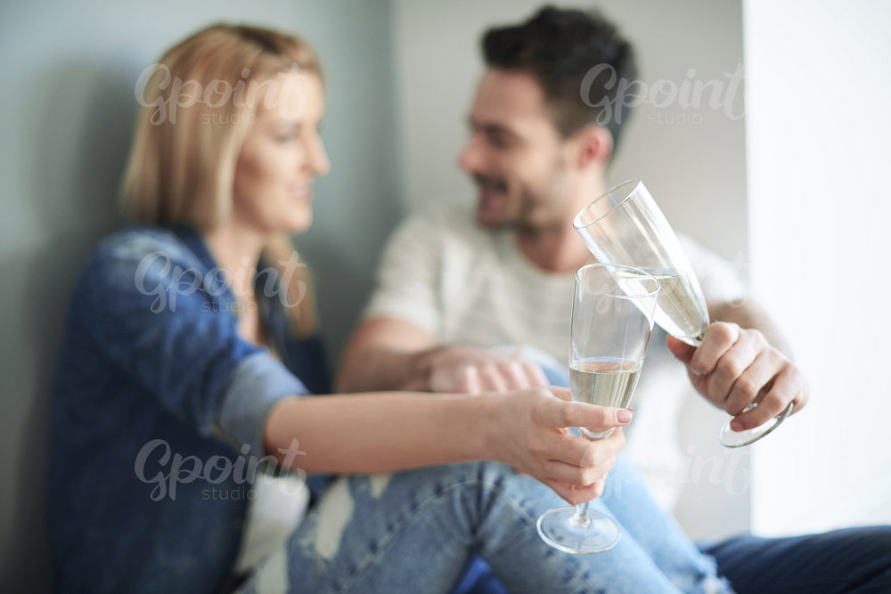 Loving couple toasting new home with champagne